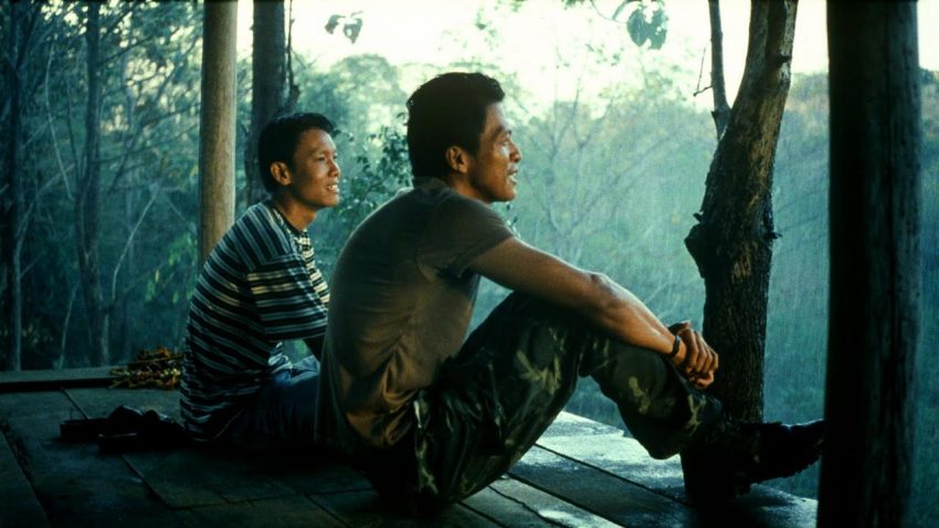 Sakda Kaewbuadee and Banlop Lomnoi sitting and talking in a forest pavilion in Tropical Malady