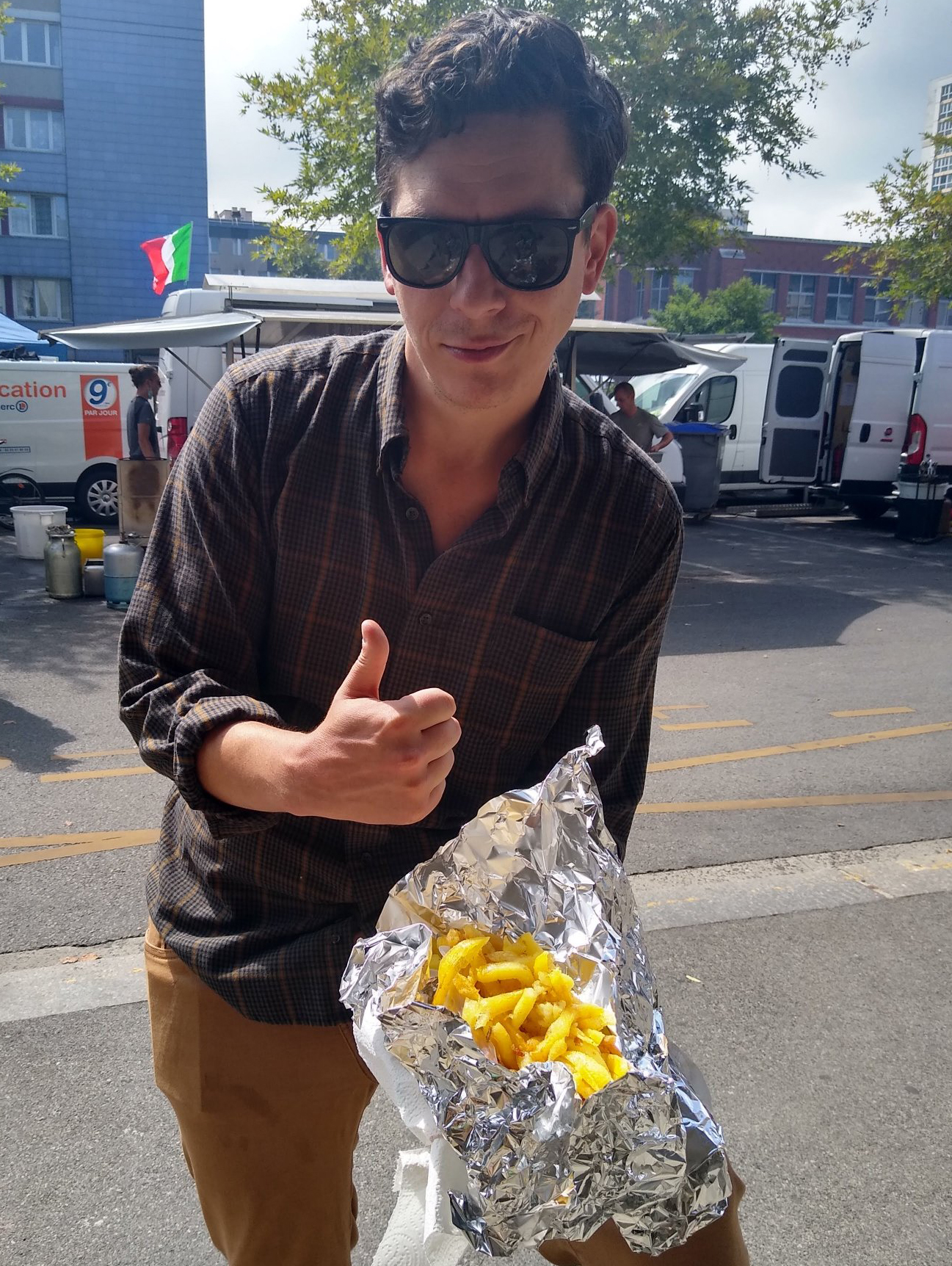 Pete in Cherbourg, France, showing off a heaping pile of frites from a street vendor.